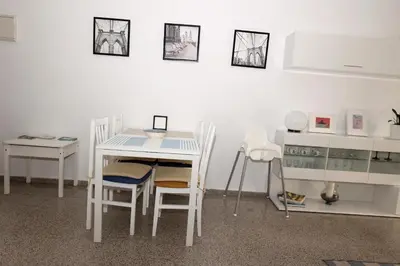 a white dining room with a table and chairs at Apartamento dos habitaciones primera línea de playa in Valencia