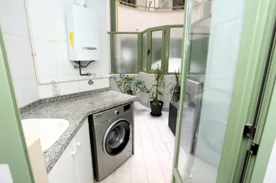 a bathroom with a washing machine and a sink at Apartamento dos habitaciones primera línea de playa in Valencia