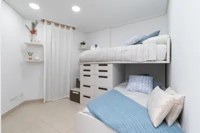 a bedroom with a bunk bed with a blue blanket at Veramar Beach Apartment in Valencia