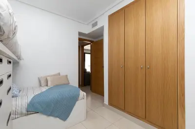 a bedroom with a bed and wooden cabinets at Veramar Beach Apartment in Valencia