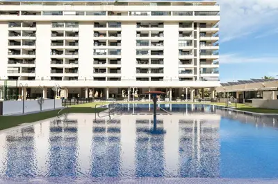 a building with a swimming pool in front of a building at Veramar Beach Apartment in Valencia