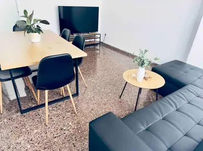 a living room with a couch and a table and a tv at Citadella Apartment in Puerto de Sagunto
