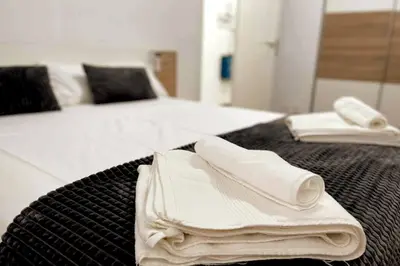 two beds with white towels on top of them at Citadella Apartment in Puerto de Sagunto
