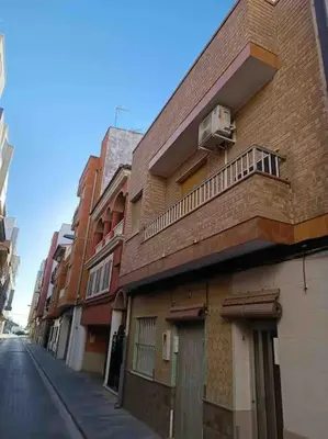 a brick building with a balcony on the side of a street at Citadella Apartment in Puerto de Sagunto