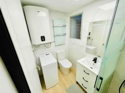 a white bathroom with a toilet and a sink at Citadella Apartment in Puerto de Sagunto