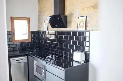 a kitchen with a black tiled counter with a sink at PR27 in Valencia