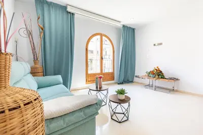 a living room with a blue couch and a window at Aparthotel Mediterráneo by NeoHotels-Centro 8 min by Metro in Valencia