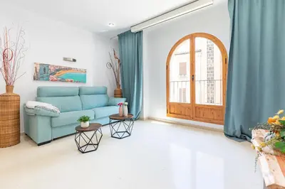 a living room with a blue couch and a window at Aparthotel Mediterráneo by NeoHotels-Centro 8 min by Metro in Valencia
