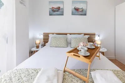 a white bedroom with a bed and a table at Aparthotel Mediterráneo by NeoHotels-Centro 8 min by Metro in Valencia