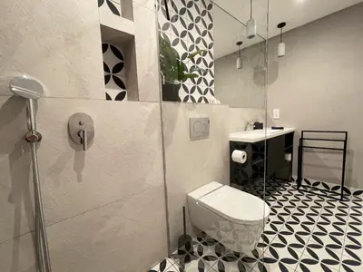 a bathroom with a toilet and a glass shower at Colina del Sol Penthouse Horizonte in Cullera