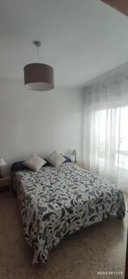 a bedroom with a bed with a black and white blanket at Apartamento 1ª línea de Playa in Puebla de Farnals