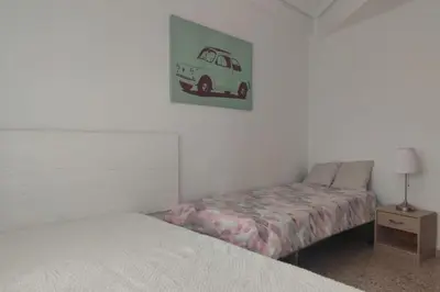 a bedroom with a bed and a van picture on the wall at Apartamento 1ª línea de Playa in Puebla de Farnals