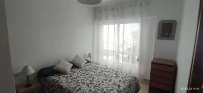 a white bedroom with a bed and a window at Apartamento 1ª línea de Playa in Puebla de Farnals