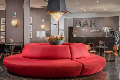 a red couch in a room with a bar at Hotel Medium Valencia in Valencia