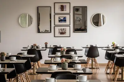 an empty restaurant with tables and chairs and mirrors at Hotel Medium Valencia in Valencia