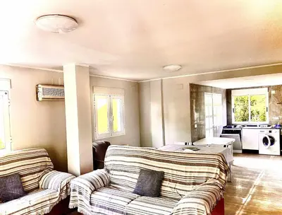 a living room with two couches and a kitchen at Casa Las Emilias en La Cañada in Partida de La Cañada