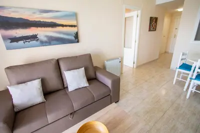 a living room with a couch and a painting on the wall at ESPACIO 18 - Primera Línea de Playa in Cullera