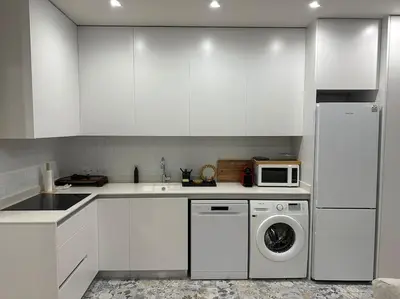 a kitchen with white cabinets and a washing machine at Precioso apartamento con patio. PYP in Valencia