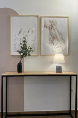 a table with a lamp and two pictures on the wall at SingularStays Arena in Valencia