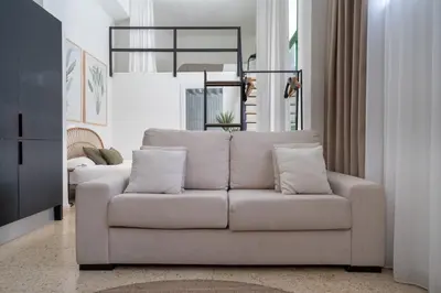 a living room with a white couch with pillows at Estudio Baleares Apartamento n3 in Valencia
