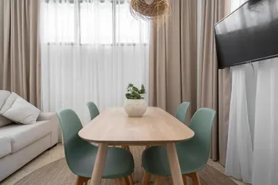 a dining room with a table and green chairs at Estudio Baleares Apartamento n3 in Valencia