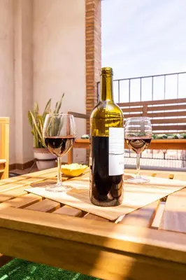 a bottle of wine sitting on a table with two glasses at Penthouse Duplex in a 4 floors spanish house -8 min to center by Metro in Valencia