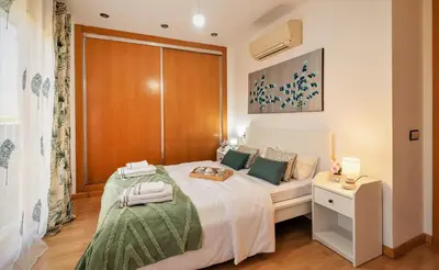 a bedroom with a white bed with a wooden wall at Penthouse Duplex in a 4 floors spanish house -8 min to center by Metro in Valencia