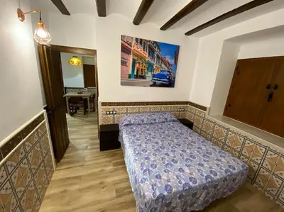 a bedroom with a bed and a hallway with a table at La Carchata in Siete Aguas