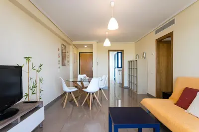 a living room with a couch and a table at ApartUP Patacona Orchard Views in Valencia