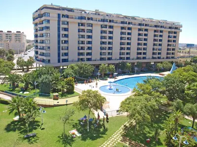 an apartment building with a swimming pool and a large building at ApartUP Patacona Orchard Views in Valencia