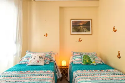 a bedroom with two beds and a picture on the wall at ApartUP Patacona Orchard Views in Valencia