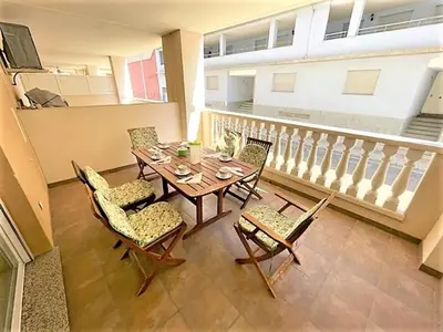 a table and chairs in a room with a balcony at Apartamento Grao de Moncofar REF. 041 in Moncófar