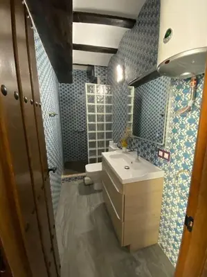 a bathroom with a sink and a toilet and blue tiles at La carchata 1 in Siete Aguas