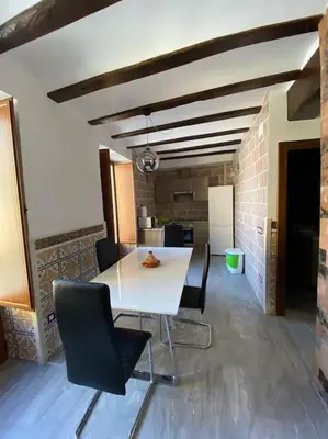 a dining room with a white table and chairs at La carchata 1 in Siete Aguas