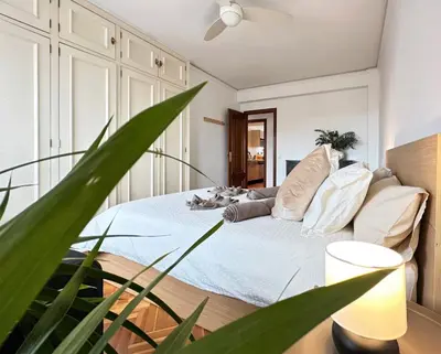 a bedroom with a bed with white walls and a plant at Your Sunny & Spacious Portview Home in Valencia