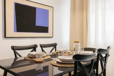 a dining room with a black table and chairs at Your Sunny & Spacious Portview Home in Valencia
