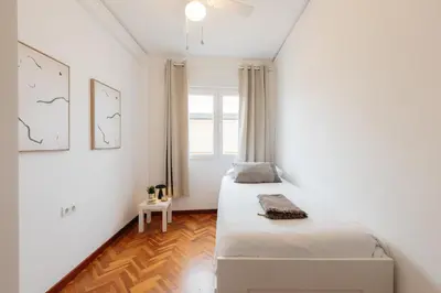 two beds in a white room with a window at Your Sunny & Spacious Portview Home in Valencia