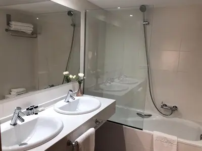 a bathroom with two sinks and a shower and a tub at Apartamentos Plaza Picasso in Valencia