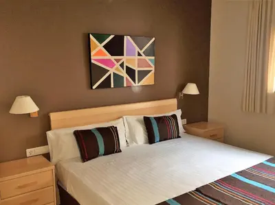 a bedroom with a bed and a painting on the wall at Apartamentos Plaza Picasso in Valencia