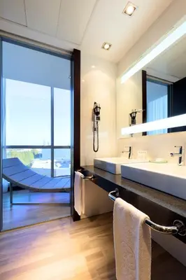 a bathroom with a large sink and a large mirror at Exe Puerto de Sagunto in Puerto de Sagunto
