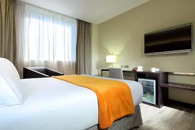 a hotel room with a bed and a flat screen tv at Exe Puerto de Sagunto in Puerto de Sagunto