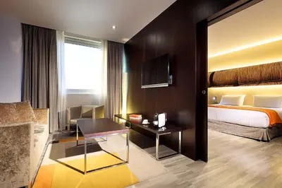 a hotel room with a bed and a desk at Exe Puerto de Sagunto in Puerto de Sagunto