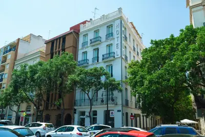 a white building with cars parked in a parking lot at Blanq Carmen Hotel in Valencia