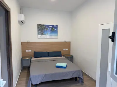 a bedroom with a bed and a table and a door at Rooms Burjassot in Burjasot