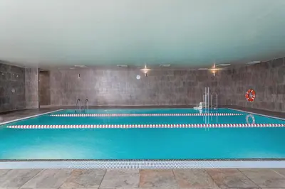 a large swimming pool with blue water in a building at AZZ Valencia Táctica Hotel in Paterna