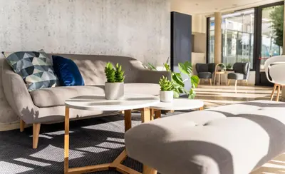 a living room with a couch and tables at AZZ Valencia Táctica Hotel in Paterna