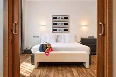 a hotel room with a bed with a bench next to it at AZZ Valencia Táctica Hotel in Paterna