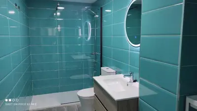a blue tiled bathroom with a sink and a toilet at APARTMENTSUITESPAIN PLAYA - UNIVERSIDADes in Valencia