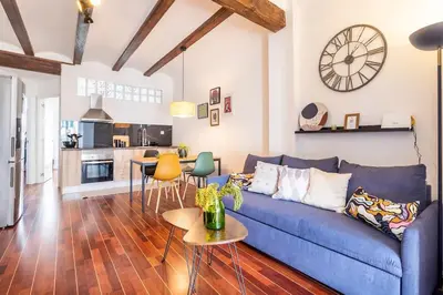 a living room with a blue couch and a kitchen at 7P céntrico piso con encanto in Valencia