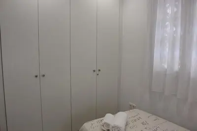 a white bedroom with white cabinets and towels on a bed at Apartamento a pie de playa in Cullera